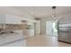 Modern kitchen with white cabinets, granite countertops and tile floor at 2572 Berrington Loop, The Villages, FL 32162