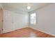 Bright bedroom with wood floors, double door closet, and window at 2572 Berrington Loop, The Villages, FL 32162