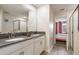 Double vanity with gray countertop, and view of a bedroom at 4550 Narrative Ln, Kissimmee, FL 34746
