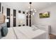 King-size bed, black and white striped walls, and modern chandelier at 4550 Narrative Ln, Kissimmee, FL 34746