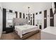 King-size bed, black and white striped walls, and modern chandelier at 4550 Narrative Ln, Kissimmee, FL 34746