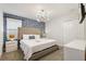 King-size bed, blue-toned wall, and modern chandelier at 4550 Narrative Ln, Kissimmee, FL 34746