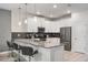 Modern kitchen with white cabinets, breakfast bar, and stainless steel appliances at 4550 Narrative Ln, Kissimmee, FL 34746