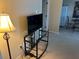 Living room featuring a glass TV stand, floor lamp, and carpeted floor at 3234 Bonnybrook S Dr, Lakeland, FL 33811