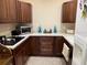 L-shaped kitchen with dark wood cabinets and appliances at 3234 Bonnybrook S Dr, Lakeland, FL 33811