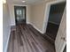 Long hallway with wood-look floors and neutral walls at 1124 Sunshine Ave, Leesburg, FL 34748