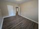 Spacious bedroom with dark laminate flooring and neutral walls at 1124 Sunshine Ave, Leesburg, FL 34748