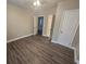 Bright bedroom featuring dark laminate floors and multiple entry points at 1124 Sunshine Ave, Leesburg, FL 34748