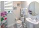 Charming powder room features a pedestal sink, round mirror, and tasteful decor at 2436 Chateau Loop, Kissimmee, FL 34741