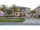 Two-story home with modern design, palm trees, and a landscaped yard at 2436 Chateau Loop, Kissimmee, FL 34741