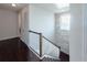 Modern staircase with white railings and a stone accent wall at 2436 Chateau Loop, Kissimmee, FL 34741