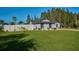 Single story home with gray exterior, landscaping, and white fence at 6294 Arborea Dr, Indian Lake Estates, FL 33855