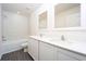 Modern bathroom with double vanity, white cabinets, and a bathtub at 13490 Leaping Water Way, Astatula, FL 34705