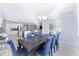 Bright dining room with a large table and blue chairs, adjacent to kitchen at 1360 Se 63Rd Court Rd, Ocala, FL 34472