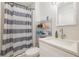Bathroom with white vanity, a shower, and a striped shower curtain at 132 James St, Auburndale, FL 33823