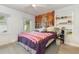 Bedroom with a large tapestry, queen-sized bed, and wood-look floors at 132 James St, Auburndale, FL 33823