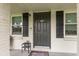 Dark gray front door with black shutters and small porch at 132 James St, Auburndale, FL 33823