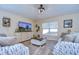 Bright living room featuring comfortable sofas, a large TV, and stylish decor at 6867 Shadowcast Ln, Lakeland, FL 33813