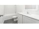 Clean bathroom with white tile, a single vanity, and gray wood-look flooring at 13470 Leaping Water Way, Astatula, FL 34705