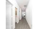 Bright hallway with gray wood-look flooring and doors leading to other rooms at 13470 Leaping Water Way, Astatula, FL 34705