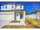 Two-story house with a blue door and landscaped walkway at 13474 Leaping Water Way, Astatula, FL 34705