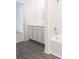 Modern bathroom featuring white shaker cabinets and grey vinyl flooring at 13486 Leaping Water Way, Astatula, FL 34705