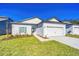 New construction home with white exterior, two-car garage, and landscaping at 13486 Leaping Water Way, Astatula, FL 34705