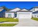 Newly built home with white exterior, two-car garage, and landscaping at 13486 Leaping Water Way, Astatula, FL 34705