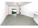 Open-concept living area with grey wood-look floors and sliding glass doors at 13486 Leaping Water Way, Astatula, FL 34705