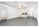 Open living area with grey wood-look floors and views into kitchen at 13486 Leaping Water Way, Astatula, FL 34705