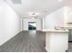 Open-concept living room with grey wood-look floors and access to backyard at 13486 Leaping Water Way, Astatula, FL 34705
