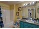 Bathroom with bathtub, shower, and teal vanity at 1111 Royal Ridge Dr, Davenport, FL 33896