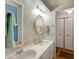 Bathroom with double sinks, oval mirror and light green tile at 1610 Reynolds Rd # 159, Lakeland, FL 33801