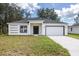 Newly constructed home with a white exterior, gray roof, and a two-car garage at 1312 Congo Dr, Poinciana, FL 34759