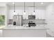 Modern kitchen with white cabinets, granite countertops, and stainless steel appliances at 1312 Congo Dr, Poinciana, FL 34759