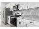 Sleek kitchen with white cabinets, granite countertops, and stainless steel appliances at 1312 Congo Dr, Poinciana, FL 34759