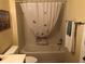 Clean and bright bathroom with a bathtub, shower, and butterfly-themed shower curtain at 2196 Kershaw Rd, The Villages, FL 32162