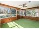 Sunroom with wood paneling, green carpet, and multiple windows at 538 Duchess Ct, Lakeland, FL 33803