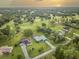 Aerial view of home on golf course at sunset at 7491 Limonia Dr, Indian Lake Estates, FL 33855