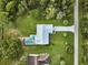 Aerial view of house, pool, and surrounding landscape at 7491 Limonia Dr, Indian Lake Estates, FL 33855
