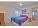 Cozy bedroom with purple bedding and a view of the backyard at 7491 Limonia Dr, Indian Lake Estates, FL 33855