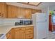 Kitchen boasts wood cabinets, white appliances, and ample counter space at 7491 Limonia Dr, Indian Lake Estates, FL 33855