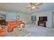 Bright living room featuring orange couches, a coffee table, and a fireplace at 7491 Limonia Dr, Indian Lake Estates, FL 33855