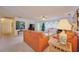 Living room with orange sofas, coffee table, and view of pool at 7491 Limonia Dr, Indian Lake Estates, FL 33855