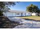Newly renovated single story home with a white exterior, gray accents, and a neatly landscaped lawn at 3733 Hill St, Lakeland, FL 33812