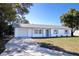 Newly renovated single story home with a white exterior, gray accents, and a neatly landscaped lawn at 3733 Hill St, Lakeland, FL 33812