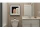 Modern bathroom with white vanity, neutral walls, and a framed piece of art at 760 Terrapin Dr, Debary, FL 32713