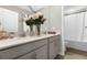 Bathroom with double vanity, gray cabinets, and a bathtub at 2613 Camden Park Loop, Davenport, FL 33837