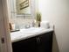 Small bathroom with a sink, dark vanity, and decorative mirror at 6855 Mossy Oak Ln, Lakeland, FL 33810