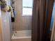 Clean bathroom with a shower/tub combo and gray tile at 6855 Mossy Oak Ln, Lakeland, FL 33810